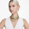 A woman wearing multiple necklaces and earrings. Produktbild-Vorschau