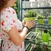 A person tending to plants in a greenhouse. Náhled obrázku produktu