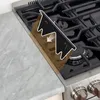 A black stove gap cover is shown being installed on a stainless steel gas stove. Anteprima dell’immagine prodotto