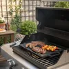A grill plate with food on it, placed on a barbecue grill in an outdoor setting. Anteprima dell’immagine prodotto