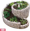 A spiral-shaped gabion raised garden bed filled with soil and various plants. Produktbild-Vorschau