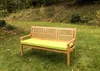 A wooden garden bench with a lime green cushion sits on a grassy lawn in a garden setting. Náhled obrázku produktu