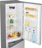 An open refrigerator showing its interior with various food items and drinks on the shelves. Podgląd zdjęcia produktu