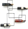 A modern, geometric metal wine rack mounted on a white wall, holding four bottles of wine. Podgląd zdjęcia produktu