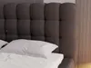 A close-up view of a bed with a dark gray tufted headboard and white bedding. Náhľad obrázku produktu
