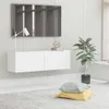 A white wall-mounted TV cabinet with a lamp and decorative items on top, in a modern living room setting. Náhľad obrázku produktu