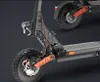 Close-up view of an electric scooter's front wheel and suspension system, with a portion of the rear wheel visible in the background. Náhled obrázku produktu