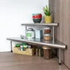A corner shelf unit with various kitchen items on it, including jars, bowls, and a plant. Produktbild-Vorschau