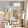 A room with a clothing rack, a mannequin, a cabinet, and a chair. Produktbild-Vorschau