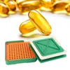 A capsule filling tool with a tray and a lid, next to several softgel capsules. Voir les images du produit