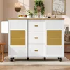 A white kitchen island with a wooden top, featuring drawers and cabinets with gold handles, is shown in a well-lit room with a rug and some decorative items. Produktbild-Vorschau