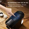 A hand pressing a button on a black espresso machine, with coffee beans and pods in the background. Produktbild-Vorschau