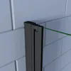 A close-up view of a black shower door frame with a green glass panel against a tiled wall. Produktbild-Vorschau