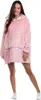 A woman is standing and posing in a pink hoodie blanket. Produktbild-Vorschau