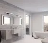 A modern bathroom with a vanity, mirror, and bathtub, featuring a city view through large windows. Podgląd zdjęcia produktu