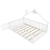 A white wooden children's bed frame with a house-shaped top and a safety rail, shown from a slightly elevated angle. Podgląd zdjęcia produktu