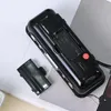 The back of a black digital alarm clock is shown, with the battery compartment open and the cover removed. Produktbild-Vorschau