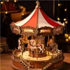 A detailed wooden carousel model with LED lights, set against a dark, bokeh-lit background. Produktbild-Vorschau