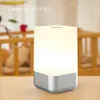 A bedside lamp with a digital display is placed on a table in front of a blurred background of a crib. Podgląd zdjęcia produktu