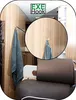 A close-up view of a clear hook holding a gray towel on a light wood-paneled wall inside a vehicle, with a leather seat in the foreground. Produktbild-Vorschau