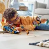 A young boy is playing with LEGO Ninjago toys on the floor. Náhľad obrázku produktu