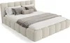A beige upholstered bed with pillows and a throw blanket. Náhled obrázku produktu