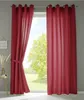A window with red curtains, a table with decorative items, and a view of trees and sky. Produktbild-Vorschau