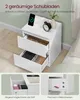 A white nightstand with two drawers open, displaying items inside. The top surface has a phone charging, an alarm clock, and a vase with a plant. Two smaller inset images show drawer details. Produktbild-Vorschau