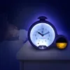 A child sleeping in bed next to a glowing alarm clock. Produktbild-Vorschau