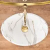 A top-down view of a marble-patterned sink with a gold faucet. Anteprima dell’immagine prodotto
