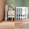 A collage showing a white foldable workstation next to a sofa on the left, and multiple folded workstations stacked on the right. Produktbild-Vorschau