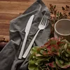 A table setting with cutlery, a napkin, and flowers. Anteprima dell’immagine prodotto