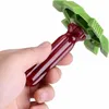 A hand holds a red and green cleaning tool. Produktbild-Vorschau