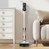 A cordless vacuum cleaner is mounted on a wall next to a dresser and a sofa. Anteprima dell’immagine prodotto
