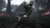 A character in a video game is fighting a large, tree-like monster in a dark, mystical forest. Produktbild-Vorschau