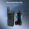 A walkie-talkie and its detachable back clip are shown against a blurred background of mountains and hikers. Náhľad obrázku produktu