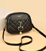 A black quilted leather handbag with a cat charm. Náhľad obrázku produktu