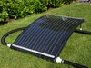 A solar pool heater is placed on a grassy lawn with green bushes in the background. Podgląd zdjęcia produktu
