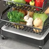 A close-up view of a multi-tiered rolling kitchen cart filled with various fresh vegetables and produce. Produktbild-Vorschau