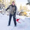 A man is shoveling snow in a snowy outdoor setting with a house and trees in the background. Náhled obrázku produktu