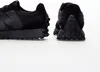 Close-up view of the back of two black New Balance sneakers on a white background. Anteprima dell’immagine prodotto