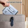 A hand is placing a folded tablet stand into a bag. Produktbild-Vorschau