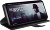 A smartphone in a black flip case is displayed, showing a movie streaming interface on its screen. Produktbild-Vorschau