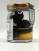 A close-up side view of a glass jar containing whole summer truffles preserved in oil, with a label attached to the lid. Podgląd zdjęcia produktu