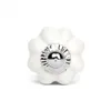 A single white ceramic knob with a silver metal accent, shaped like a flower. Produktbild-Vorschau