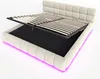 A beige upholstered bed frame with its storage compartment open, revealing a black interior and a slatted mattress base. Pink LED lighting is visible around the base of the bed. Anteprima dell’immagine prodotto
