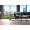 An air purifier is placed in a modern living room with a large window overlooking a city skyline. Podgląd zdjęcia produktu