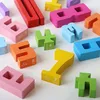 A collection of colorful wooden number blocks scattered on a white surface. Produktbild-Vorschau