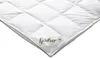 A close-up view of a white quilted duvet with a label.