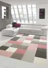 A modern living room with a white sectional sofa and a geometric patterned rug. Podgląd zdjęcia produktu